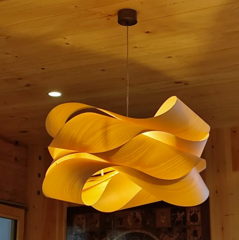 Lámpara decorativa encendida en un interior con techo de madera