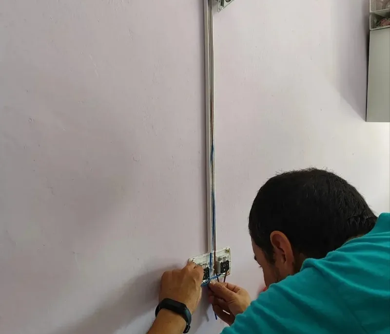 Tino conectando mecanismos eléctricos en una instalación de superficie